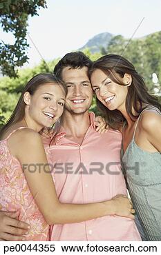 Stock Image - a young man with 
two young woman 
embracing him. 
fotosearch - search 
stock photos, 
pictures, images, 
and photo clipart