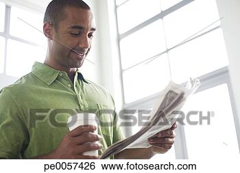 Stock Photo - businessman standing 
in office with 
newspaper and 
coffee cup. fotosearch 
- search stock 
photos, pictures, 
images, and photo 
clipart