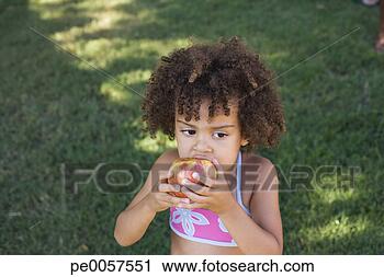 Stock Photography - girl in swimwear 
eating apple in 
yard. fotosearch 
- search stock 
photos, pictures, 
images, and photo 
clipart
