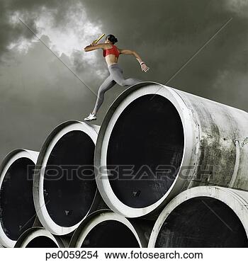 Stock Photo - relay runner with 
baton going over 
large cylinders. 
fotosearch - search 
stock photos, 
pictures, images, 
and photo clipart