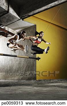 Stock Photo - two athletes jumping 
a parking garage 
barrier. fotosearch 
- search stock 
photos, pictures, 
images, and photo 
clipart
