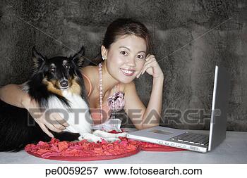 Picture - woman with dog 
and laptop indoors. 
fotosearch - search 
stock photos, 
pictures, images, 
and photo clipart