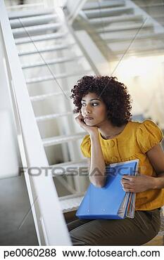 Stock Photo - businesswoman 
in office space 
with binders at 
bottom of staircase. 
fotosearch - search 
stock photos, 
pictures, images, 
and photo clipart