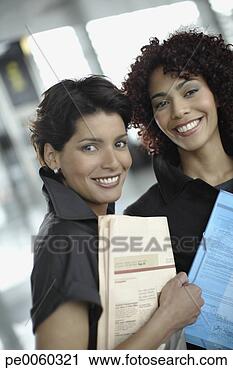 Stock Photography - two businesswomen 
in office with 
paperwork. fotosearch 
- search stock 
photos, pictures, 
images, and photo 
clipart
