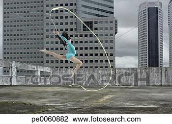 Stock Photo - woman gymnast 
outdoors on rooftop 
jumping in air 
with ribbon. fotosearch 
- search stock 
photos, pictures, 
images, and photo 
clipart