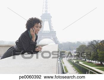 Stock Photo - woman outdoors 
on her mobile 
phone by the eiffel 
tower. fotosearch 
- search stock 
photos, pictures, 
images, and photo 
clipart
