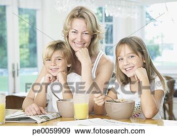 Stock Photograph - woman and two 
young kids in 
kitchen eating 
breakfast. fotosearch 
- search stock 
photos, pictures, 
images, and photo 
clipart