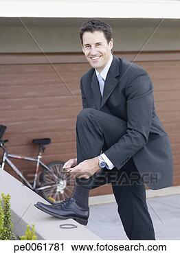 Stock Photography - businessman outdoors 
putting bicycle 
clips on his pants. 
fotosearch - search 
stock photos, 
pictures, images, 
and photo clipart