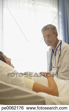Stock Photo - doctor in hospital 
room talking to 
patient in bed 
and smiling. fotosearch 
- search stock 
photos, pictures, 
images, and photo 
clipart