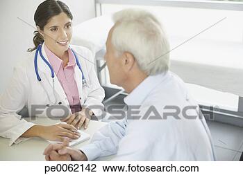 Stock Photo - doctor sitting 
in office with 
patient talking 
and smiling. fotosearch 
- search stock 
photos, pictures, 
images, and photo 
clipart