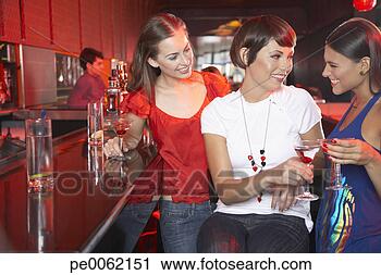 Stock Photography - three women in 
nightclub at bar 
with beverages 
toasting and smiling. 
fotosearch - search 
stock photos, 
pictures, images, 
and photo clipart