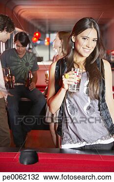 Stock Photo - woman with beverage 
standing by pool 
table smiling. 
fotosearch - search 
stock photos, 
pictures, images, 
and photo clipart