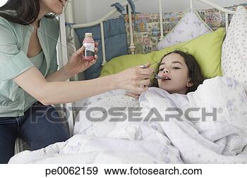 Stock Photograph - woman helping 
young girl take 
medicine in bedroom. 
fotosearch - search 
stock photos, 
pictures, images, 
and photo clipart