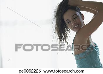Stock Image - woman indoors 
with hands in 
hair smiling. 
fotosearch - search 
stock photos, 
pictures, images, 
and photo clipart