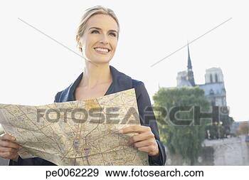 Stock Photograph - woman outdoors 
holding map and 
smiling. fotosearch 
- search stock 
photos, pictures, 
images, and photo 
clipart