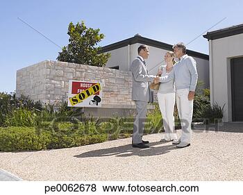 Stock Photo - couple shaking 
hands with real 
estate agent at 
new home. fotosearch 
- search stock 
photos, pictures, 
images, and photo 
clipart
