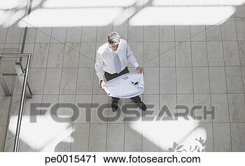 Stock Photography - aerial view of 
businessman with 
blueprints. fotosearch 
- search stock 
photos, pictures, 
images, and photo 
clipart