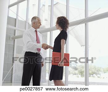 Picture - businesswoman 
with document 
shaking hands 
with businessman. 
fotosearch - search 
stock photos, 
pictures, images, 
and photo clipart