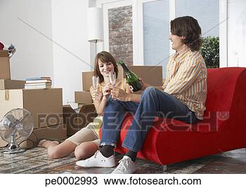 Stock Photo - couple with champagne 
in house with 
red chair celebrating. 
fotosearch - search 
stock photos, 
pictures, images, 
and photo clipart
