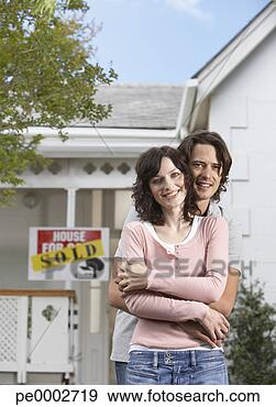 Stock Photograph - man and woman 
embracing in front 
of house with 
sold sign. fotosearch 
- search stock 
photos, pictures, 
images, and photo 
clipart