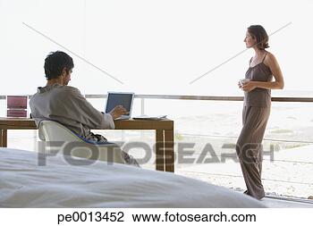 Stock Photo - man at computer 
and woman standing 
with large windows. 
fotosearch - search 
stock photos, 
pictures, images, 
and photo clipart