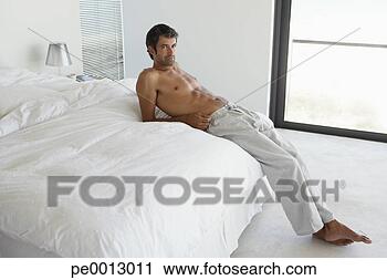 Stock Photography - man reclining 
on bed. fotosearch 
- search stock 
photos, pictures, 
images, and photo 
clipart