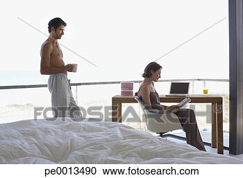 Stock Photography - woman at laptop 
and man in room 
with large windows. 
fotosearch - search 
stock photos, 
pictures, images, 
and photo clipart