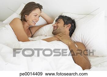 Stock Photograph - woman and man 
lying down in 
bed. fotosearch 
- search stock 
photos, pictures, 
images, and photo 
clipart