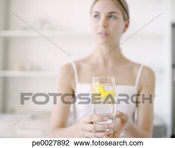 Stock Photo - woman holding 
glass of water 
with lemon. fotosearch 
- search stock 
photos, pictures, 
images, and photo 
clipart