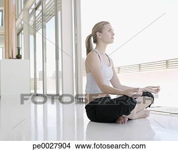 Stock Photo - woman sitting 
cross legged doing 
yoga. fotosearch 
- search stock 
photos, pictures, 
images, and photo 
clipart