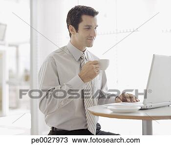 Stock Photo - businessman with 
coffee cup and 
laptop. fotosearch 
- search stock 
photos, pictures, 
images, and photo 
clipart