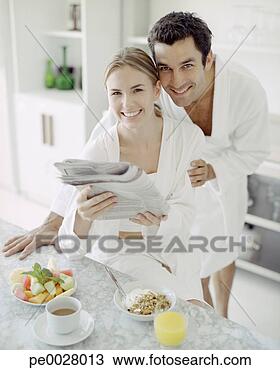 Stock Photo - man and woman 
in bathrobes with 
healthy breakfast 
reading newspaper. 
fotosearch - search 
stock photos, 
pictures, images, 
and photo clipart