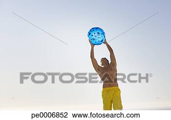Stock Photo - man in swimsuit 
with beach ball 
outdoors. fotosearch 
- search stock 
photos, pictures, 
images, and photo 
clipart