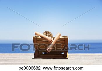 Stock Photo - rear view of woman 
reclining on folding 
chair outdoors. 
fotosearch - search 
stock photos, 
pictures, images, 
and photo clipart