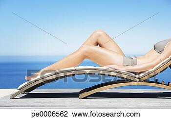 Stock Photo - woman reclining 
on folding chair 
in bikini outdoors. 
fotosearch - search 
stock photos, 
pictures, images, 
and photo clipart