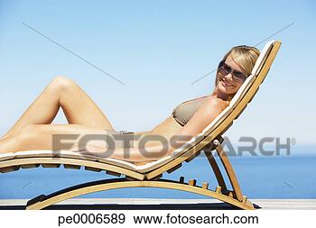 Stock Photograph - woman reclining 
on folding chair 
in bikini outdoors. 
fotosearch - search 
stock photos, 
pictures, images, 
and photo clipart
