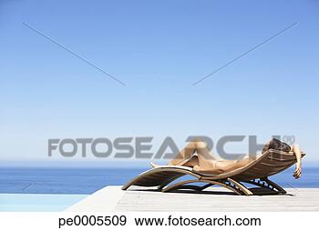 Stock Photograph - woman in bikini 
lying down on 
folding chair 
outdoors with 
water. fotosearch 
- search stock 
photos, pictures, 
images, and photo 
clipart