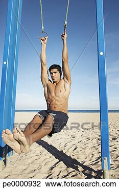 Stock Photo - man on a beach 
working out on 
exercise rings 
apparatus. fotosearch 
- search stock 
photos, pictures, 
images, and photo 
clipart