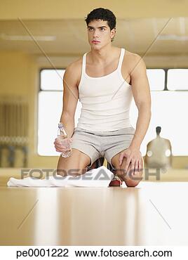 Stock Photo - man taking a break 
from working out 
in a fitness studio. 
fotosearch - search 
stock photos, 
pictures, images, 
and photo clipart