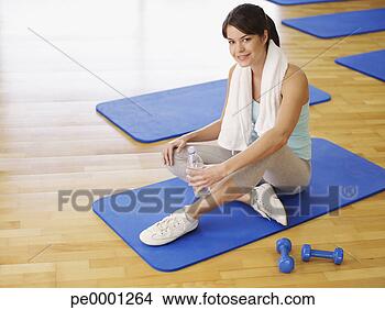 Stock Photo - woman taking a 
break from doing 
mat exercises 
in a fitness studio. 
fotosearch - search 
stock photos, 
pictures, images, 
and photo clipart