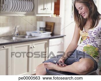 Banco de Imagem - adolescente,  
menina,  célula, 
 telefone,  cozinha, 
 sorrindo. fotosearch 
- busca de fotos, 
imagens e clipart