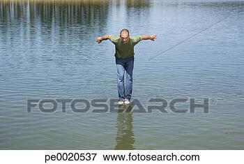 Foto - homem,  ficar, 
 água,  aproximadamente, 
 salto. fotosearch 
- busca de fotos, 
imagens e clipart
