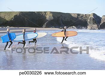 Stock Photo - four adults with 
surfboards running 
into the water. 
fotosearch - search 
stock photos, 
pictures, images, 
and photo clipart