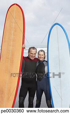 Arquivo de Fotografias - velho,  par,  
segurando,  surfboards. 
fotosearch - busca 
de fotos, imagens 
e clipart