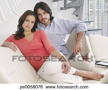 Stock Photo - couple relaxing 
on sofa with television 
remote. fotosearch 
- search stock 
photos, pictures, 
images, and photo 
clipart