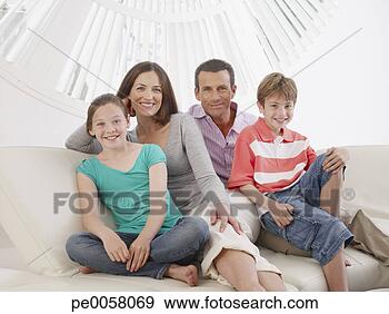 Stock Photograph - couple with young 
boy and girl sitting 
on sofa together 
smiling. fotosearch 
- search stock 
photos, pictures, 
images, and photo 
clipart