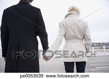 Stock Photograph - a couple on a 
boardwalk at the 
beach. fotosearch 
- search stock 
photos, pictures, 
images, and photo 
clipart