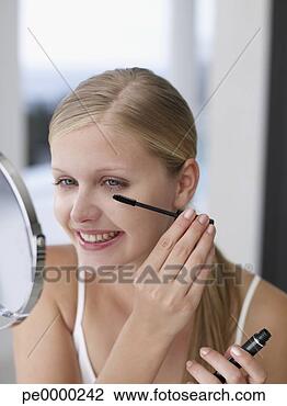 Banco de Imagem - sorrindo,  mulher, 
 aplicando,  mascara, 
 espelho. fotosearch 
- busca de fotos, 
imagens e clipart