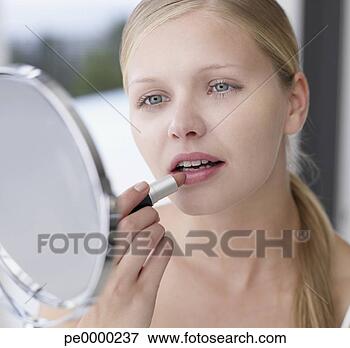 Picture - woman applying 
lipstick in mirror. 
fotosearch - search 
stock photos, 
pictures, images, 
and photo clipart