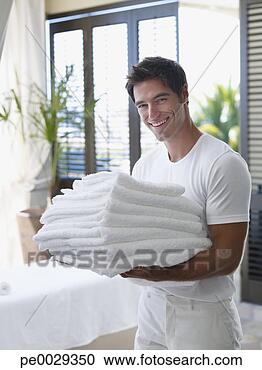 Arquivo de Fotografias - homem,  pilha, 
 toalhas,  seu, 
 braços. fotosearch 
- busca de fotos, 
imagens e clipart